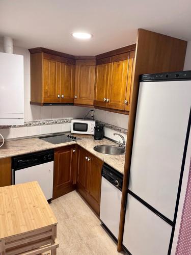 a kitchen with wooden cabinets and a white refrigerator at TramaCalm in Tramacastilla de Tena