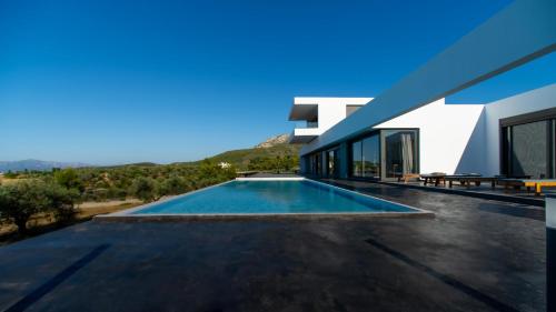 uma vista para uma casa com piscina em Villa Scorpios Attica em Áyioi Apóstoloi