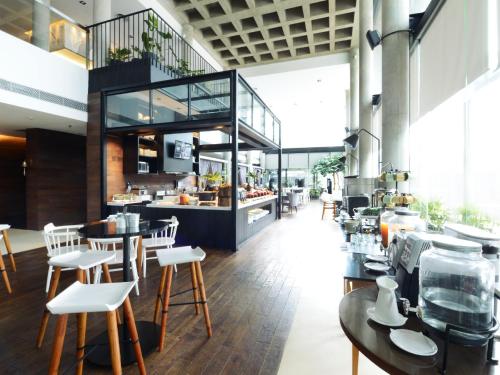 a restaurant with tables and chairs and a counter at Morrissey Hotel Residences in Jakarta