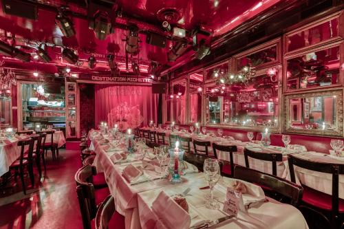 une salle à manger avec des tables et des chaises et des murs roses dans l'établissement Pigalle Montmartre - Studio LaGoulue - 25 m2 - 2 minutes de la station Métro Pigalle - 2 lits simples type gigogne pour 2-3 personnes -Quartier Hypertouristique -Cabaret Moulin Rouge à 200-Café Aux Noctambules-Cabaret chez Michou-Restaurants théâtres, à Paris