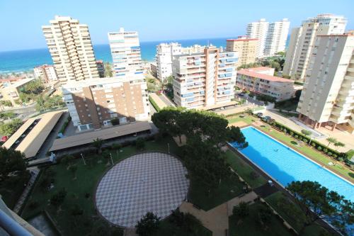 una vista aérea de una ciudad con piscina y edificios en 1 min a pie Playa San Juan - Increíbles vistas al mar - 4 habs - Gran terraza - Urbanización con piscina padel y tenis, en Alicante