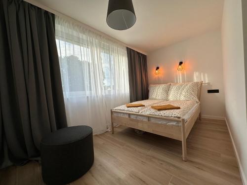 una camera con letto, finestra e sedia di Apartament Michałek a Mielno