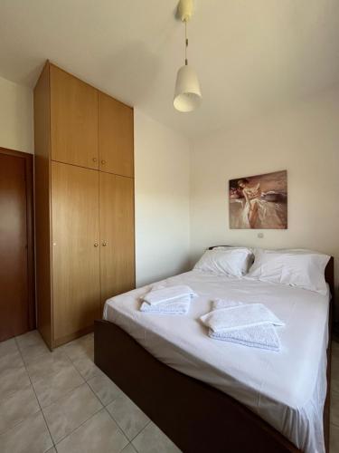 a bedroom with a bed with white sheets and a cabinet at Argoules House in Argoulés