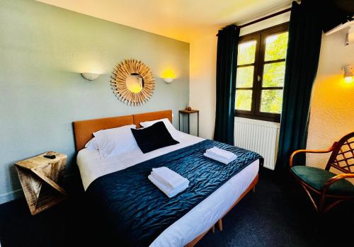 een slaapkamer met een bed met een spiegel en een stoel bij L'Escoundillou in Saint-Jacques-des-Blats