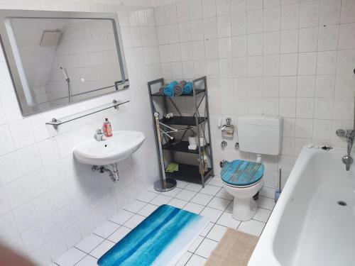 een badkamer met een wastafel, een toilet en een spiegel bij Ferienwohnung Havel-Ausblick in Havelberg