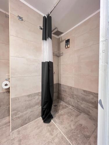 a shower with a black shower curtain in a bathroom at Modern & Cozy 51sqm Apt in Thisseio in Athens