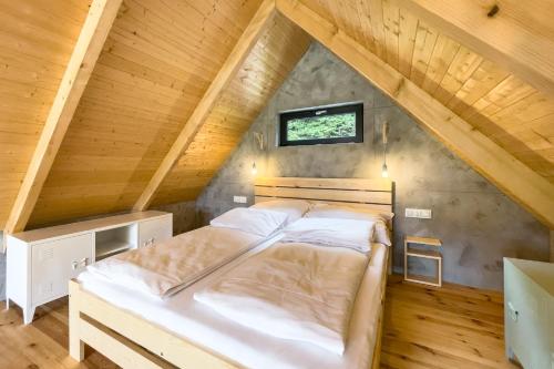 a bedroom with a bed in a attic at Stodoły Modyń - Domki w Beskidzie Wyspowym - staw kąpielowy, balia, sauna, grota solna - widok na góry in Kamienica
