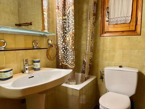 ein Badezimmer mit einem weißen WC und einem Waschbecken in der Unterkunft Piso Puigcerda vistas y piscina in Puigcerdà