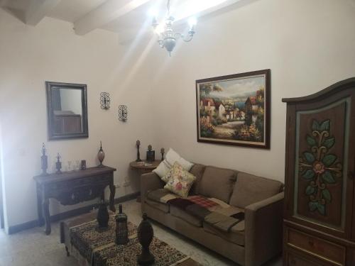 a living room with a couch and a painting on the wall at Casa Chelito con Terraza in Guanajuato