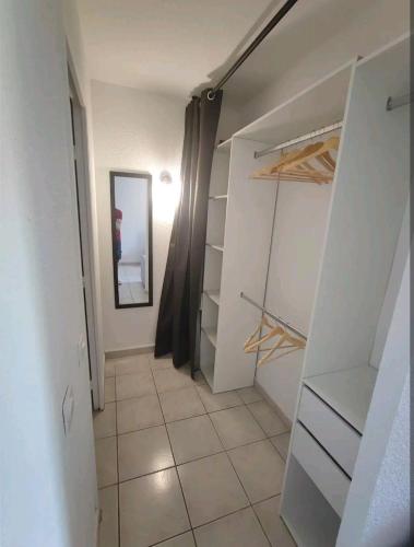 Elle comprend un dressing avec des placards blancs et du carrelage. dans l'établissement 2 pièces proche plage + parking, au Golfe-Juan