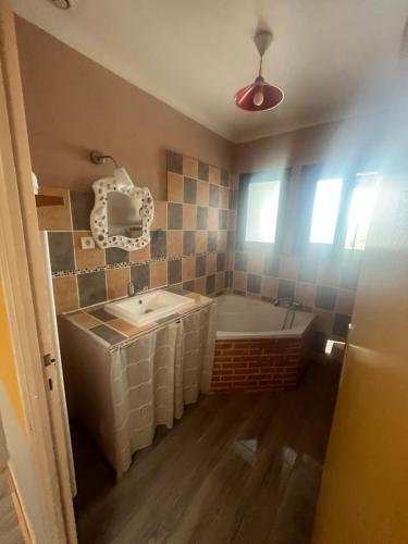 une salle de bain avec une baignoire et un lavabo dans l'établissement Maison de campagne style mas, à Camélas