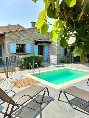 une piscine avec deux chaises à côté d'une maison dans l'établissement Maison Provençale Spa Sauna Piscine, à Mollégès