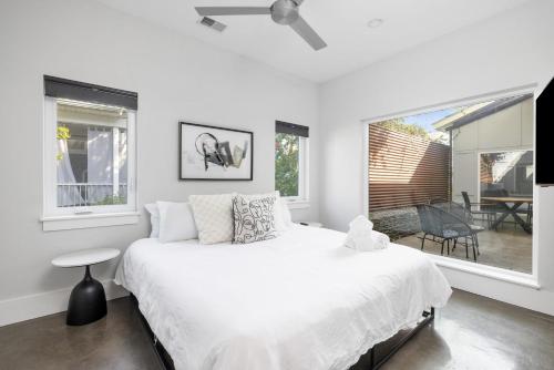 een witte slaapkamer met een groot bed en ramen bij The Polygon Park Circle Mins to Dwtn and Beach in Charleston