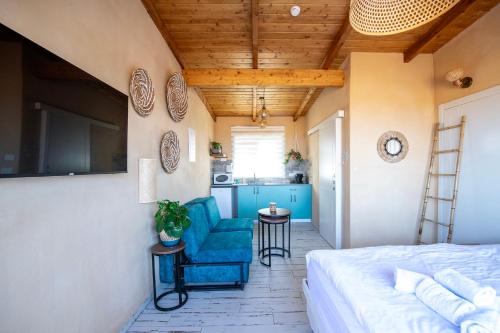 - une chambre avec un lit et une chaise bleue dans l'établissement בריאה אירוח בטבע, à Sha'al