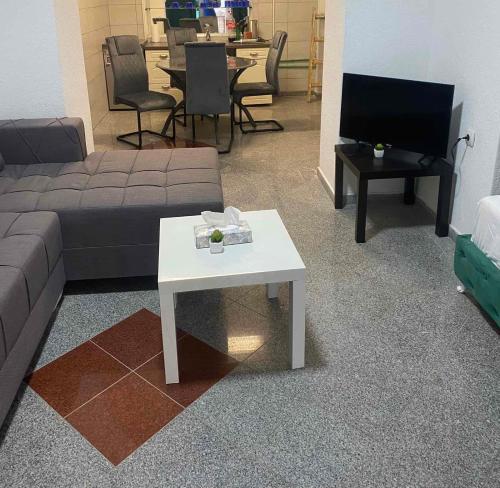 sala de estar con sofá y mesa en Mrkonjić Grad Apartmani, en Mrkonjić Grad