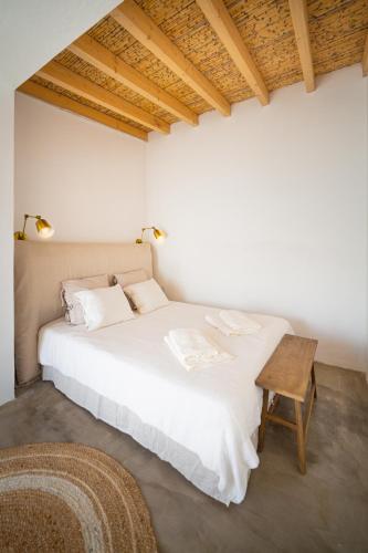 a white bed in a room with a wooden ceiling at Calma Boutique House in Vila Nova De Cacela
