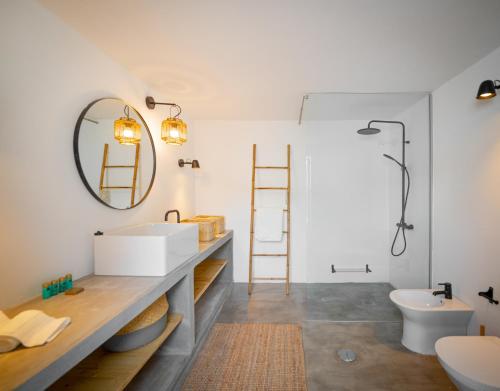 a bathroom with a sink and a mirror at Calma Boutique House in Vila Nova De Cacela
