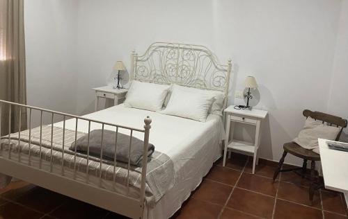um quarto com uma cama branca e duas mesas de cabeceira em El Balcón de Alange em Alange