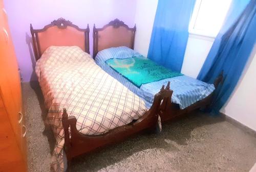 2 camas individuales en una habitación con cortinas azules en Pellegrini Departamentos muy confortable y bien ubicado en Godoy Cruz