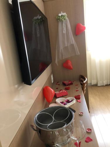 a kitchen counter with a table with red hearts on the wall at Pratti Hotel in Linhares