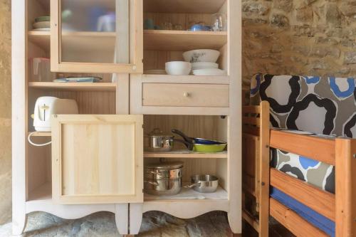 un armario con platos y utensilios en la cocina en El Telar, en Rasines