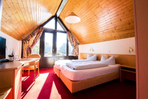 um quarto com uma cama, uma secretária e uma janela em Hotel Strand-Café em Roßbach