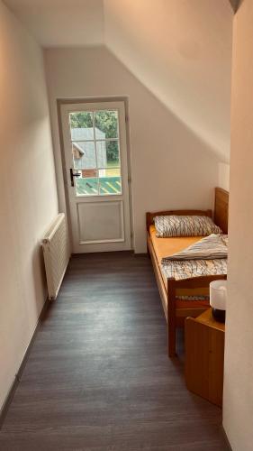 a room with two beds and a door at Horské Apartmány Smrčina in Janske Lazne