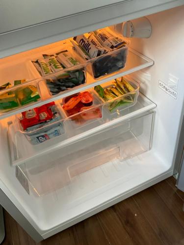 - un réfrigérateur avec une porte ouverte avec de la nourriture à l'intérieur dans l'établissement Self contained guest Flat, à Wick