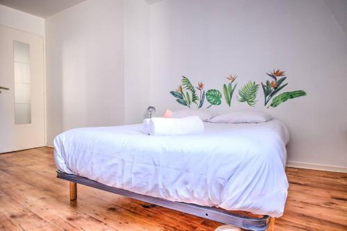 sypialnia z białym łóżkiem z roślinami na ścianie w obiekcie Le Jardin Suspendu Charme & Calme en centre ville w mieście Périgueux
