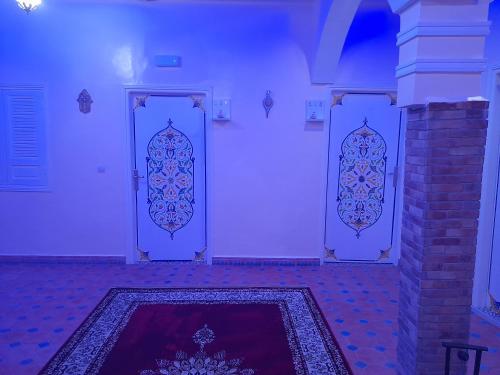 two doors in a room with a rug on the floor at Hotel Mentaga in Taroudant