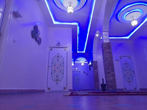 a room with purple lights and a staircase and doors at Hotel Mentaga in Taroudant
