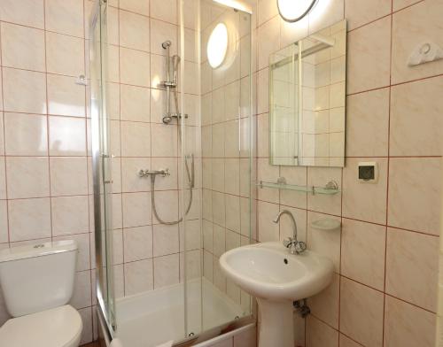 a bathroom with a shower and a sink and a toilet at Willa Agawa in Jastrzębia Góra