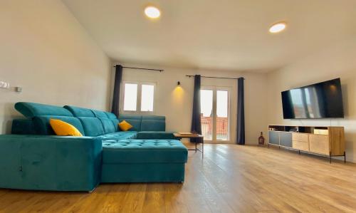 sala de estar con sofá azul y TV de pantalla plana en West Apartments, en Zadar