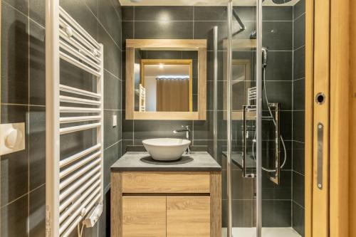 a bathroom with a sink and a glass shower at Ridge302 in Bourg-Saint-Maurice