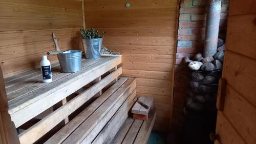 een houten bank in een sauna met een wastafel bij Plesumi 