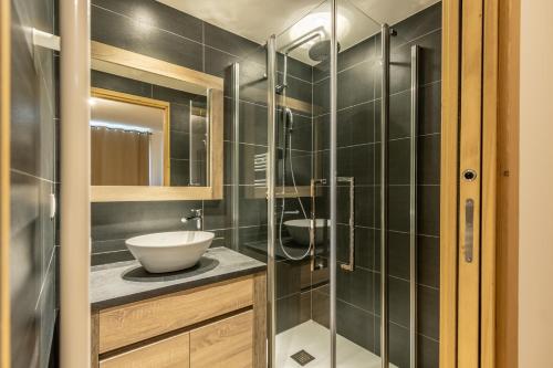 a bathroom with a sink and a glass shower at Ridge302 in Bourg-Saint-Maurice