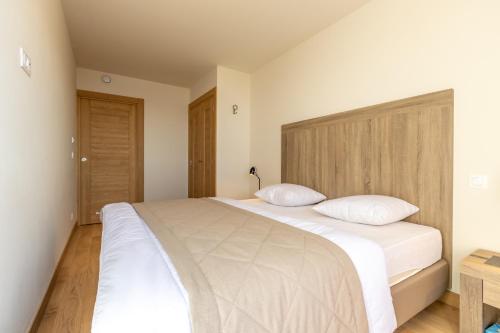 a bedroom with a large white bed with two pillows at Ridge302 in Bourg-Saint-Maurice