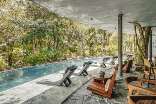 a pool with a bunch of chairs next to it at Tropical Oasis with Plunge Pool & Peaceful Garden - Mira Luna 131C in Tulum