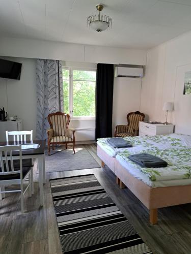 a bedroom with a bed and a table and chairs at Villa Saimaan Sydän in Puumala