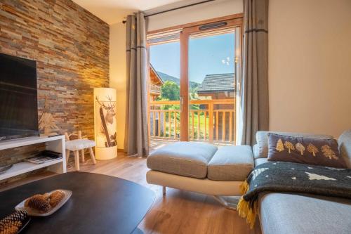 a living room with a couch and a large window at Chalet Gaïla in Méribel