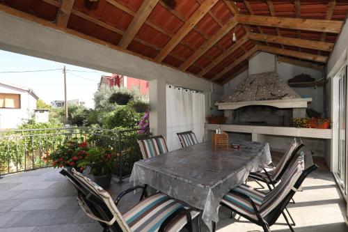 eine Terrasse mit einem Tisch und Stühlen sowie einem Backofen im Freien in der Unterkunft Sea Relaxing Apartment in Bibinje