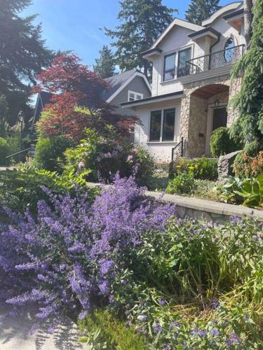 a house with purple flowers in front of it at 温西民宿 Vancouver West Quiet Home in Vancouver