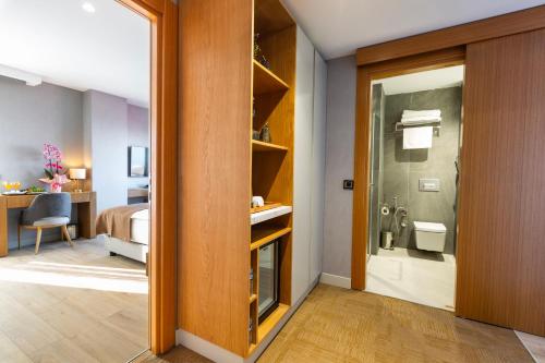 a room with a bathroom with a shower and a bedroom at North Star Suite Hotel in Trabzon