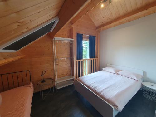 MeldersloにあるRecreatiewoning De NieuwenHofの木造キャビン内のベッド1台が備わるベッドルーム1室を利用します。