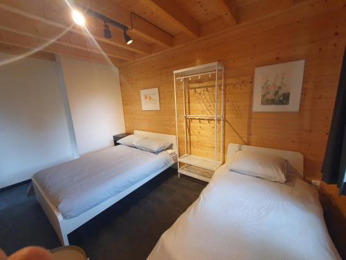 two beds in a room with a window at Recreatiewoning De NieuwenHof in Melderslo