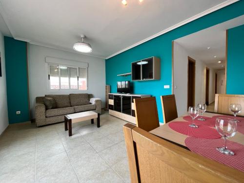 sala de estar con sofá y mesa con copas de vino en ACV - Torremar-2ª linea planta 7 Frontal, en Oropesa del Mar