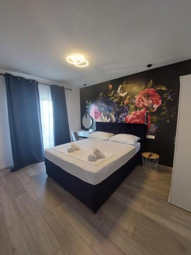 a bedroom with a large bed with a painting on the wall at Apartman MariLu in Drašnice