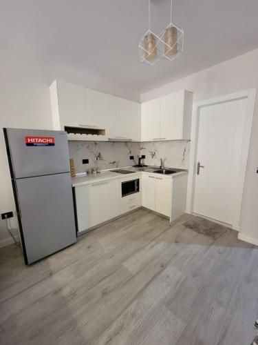 een lege keuken met witte kasten en een koelkast bij Small Studio near the Olimpik Park in Tirana