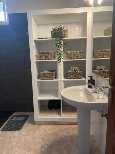 a bathroom with a sink and a shelf at Casa Feluca in Breña Alta