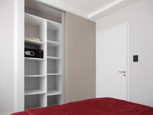 ein Schlafzimmer mit weißen Wänden und einem roten Bett in der Unterkunft Edificio Parana in Santa Rosa